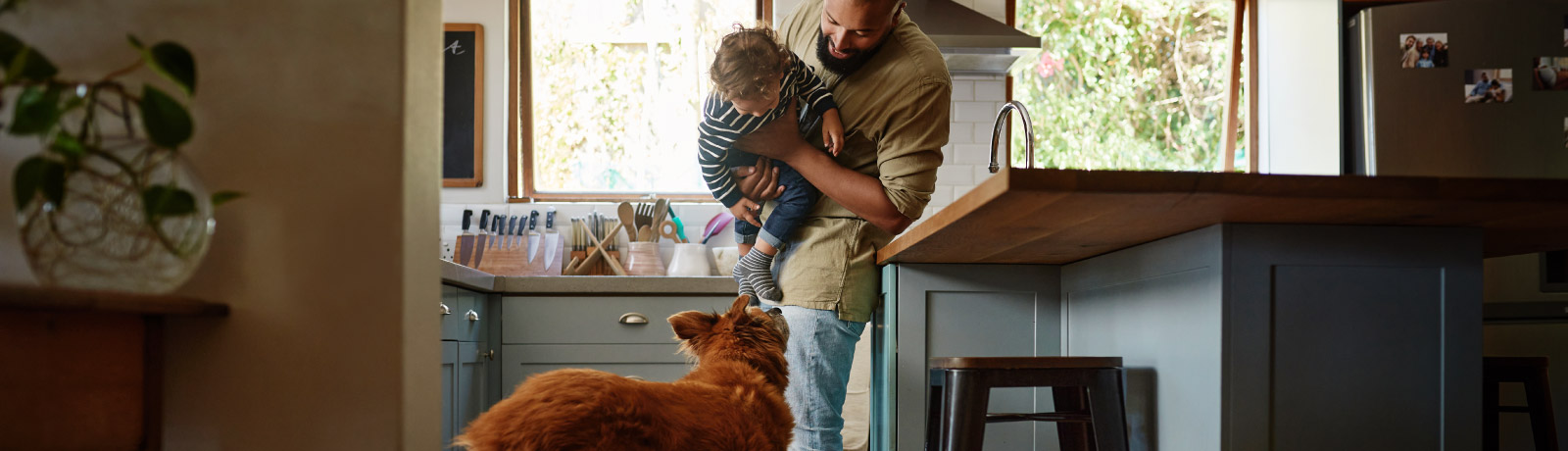 a father with his son and dog in the kitchen