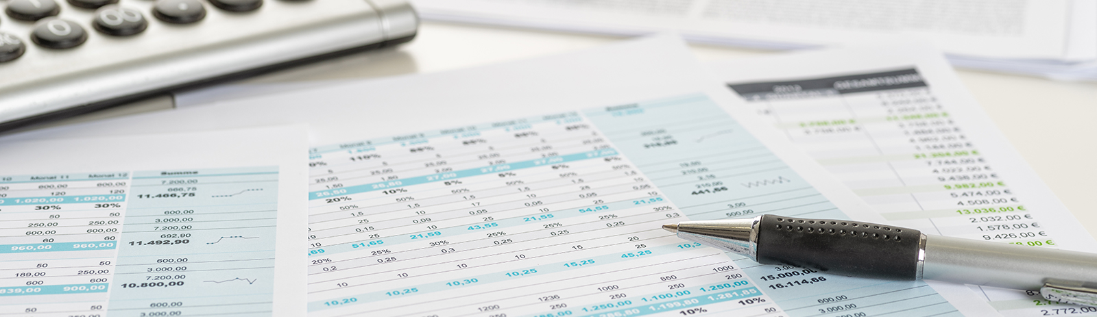 financial documents next to a calculator and writing pen