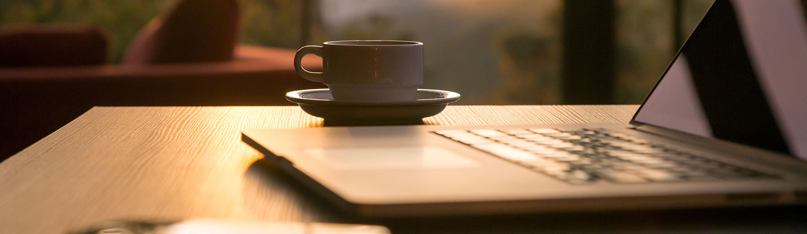 a cup of coffee next to a laptop